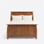 Front view of a Craftsman panel bed, showing a tall four-panel headboard behind a footboard with an arched lower rail.