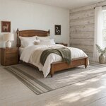 Diagonal angled room view showing the right side of a traditional post bed with an arched headboard, in a log cabin bedroom.