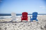 Patriotic Red, White, and Blue Amish Poly Adirondack Chairs at the beach overlooking the ocean