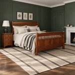 Diagonal angled room view showing the right side of a Mission panel bed with a slatted footboard, in a green-paneled bedroom.