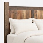 Headboard close-up of a farmhouse panel bed, showing vertical plank panels split by a center stile under a flat top rail.