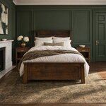 Front room view of a transitional panel bed with slim headboard cutouts, in a green-paneled bedroom with a fireplace.