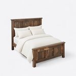 High angled view of a farmhouse panel bed, looking down on the plank-paneled ends, side rails and square legs.