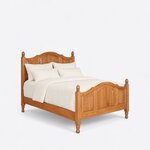 Diagonal angled view showing the right side of a traditional panel bed, with arched three-panel ends and acorn finials.
