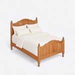 High angled view of a traditional panel bed, looking down on the arched crests, three-panel footboard and turned feet.