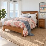 Diagonal angled room view showing the left side of a Shaker panel bed with a low footboard, in a white coastal bedroom.