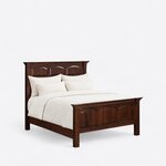 Diagonal angled view showing the right side of a traditional panel bed, with arched raised panels and rope-molded crowns.