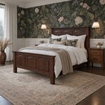 Diagonal angled room view showing the left side of a traditional panel bed with arched panels, in a floral-papered bedroom.