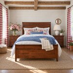 Front room view of a classic sleigh bed with a recessed-panel footboard, in a shiplap bedroom with exposed ceiling beams.