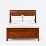 Front view of a classic sleigh bed, showing a tall rolled-top headboard and a low recessed-panel footboard on straight legs.