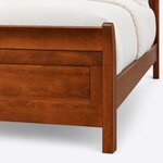 Footboard close-up of a classic sleigh bed, showing the outward-flared corner post, a recessed panel and a straight leg.