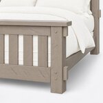 Footboard close-up of a rustic slat bed, showing the overhanging cap, a pegged corner post with tenon ends and a square leg.