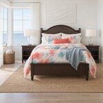 Front room view of a traditional storage bed with an arched headboard, in a coastal bedroom with an ocean-view window.