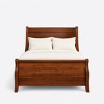 Front view of a traditional sleigh bed, showing a tall rolled headboard and a plank-paneled footboard with S-curved sides.