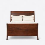 Front view of a modern sleigh bed, showing a tall swept-back headboard and a high panel footboard on flared legs.