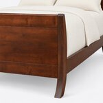 Footboard close-up of a modern sleigh bed, showing the curved corner post with a rounded top flaring into a splayed foot.