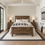 Front room view of a rustic panel bed with a two-panel headboard, in a shiplap bedroom with a beamed vaulted ceiling.