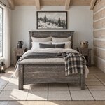 Front room view of a rustic panel bed with a plank headboard and footboard, in a log cabin bedroom with a beamed ceiling.