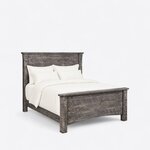 Diagonal angled view showing the right side of a rustic panel bed, with a planked headboard and a matching footboard.