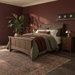 Diagonal angled room view showing the left side of a Mission panel bed with a paneled headboard, in a burgundy bedroom.