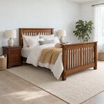 Diagonal angled room view showing the right side of a Mission slat bed with a high slatted footboard, in a white bedroom.
