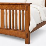 Footboard close-up of a Mission slat bed, showing exposed tenons on a square post, the overhanging cap and an arched rail.