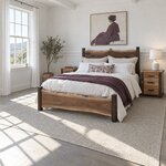 Diagonal angled room view showing the left side of a live edge panel bed with a low slab footboard, in a white bedroom.