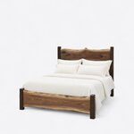 Diagonal angled view showing the left side of a live edge panel bed, with a crested headboard and a low slab footboard.