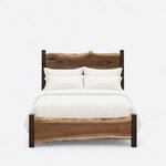 Front view of a live edge panel bed, showing a tall crested slab headboard and a low slab footboard between square posts.