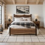Front room view of a live edge panel bed with a crested slab headboard, in a log cabin bedroom with a beamed ceiling.