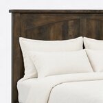 Headboard close-up of a Mission panel bed, showing an arched recessed panel, a square post and the overhanging cap rail.