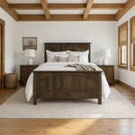 Front room view of a Mission panel bed with an arched two-panel footboard, in a white bedroom with a beamed ceiling.