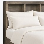 Headboard close-up of a contemporary bookcase bed, showing open cubbies with square dividers under a mitered top frame.