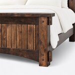 Footboard close-up of a Mission panel bed, showing the overhanging cap, a pegged post with tenon blocks and an arched rail.