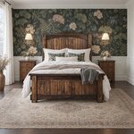 Front room view of a Mission panel bed with an arched plank headboard, in a bedroom with floral wallpaper over wainscoting.