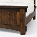 Footboard close-up of a Mission panel bed, showing the overhanging cap, tenon blocks, a pegged post and an arched rail.