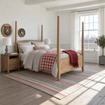 Diagonal angled room view showing the right side of a classic pencil post bed with tall posts, in a white farmhouse bedroom.