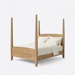 Diagonal angled view showing the left side of a classic pencil post bed, with tall tapered posts and an arched footboard.
