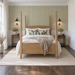 Front room view of a classic pencil post bed with tall tapered posts, in a bedroom with striped wallpaper over wainscoting.