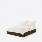Diagonal angled view showing the left side of a minimalist platform bed, with a low box frame and three side drawers.