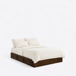 Diagonal angled view showing the right side of a minimalist platform bed, with a low box frame and three side drawers.