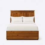 Front view of a Mission storage bed, showing a tall flared headboard with an overhanging cap over a low solid footboard.