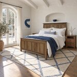 Diagonal angled room view showing the left side of a Mission panel bed with a panel footboard, in a white plaster bedroom.