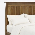 Headboard close-up of a Mission panel bed, showing the overhanging cap, an inlaid arched top rail and recessed panels.