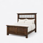 Diagonal angled view showing the left side of an industrial panel bed, with a metal grid headboard and metal corner straps.