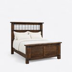 Diagonal angled view showing the right side of an industrial panel bed, with a metal grid headboard and metal corner straps.