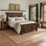 Diagonal angled room view showing the right side of a rustic panel bed with a star footboard, in a terracotta-tiled bedroom.