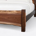Footboard close-up of a live edge panel bed, showing the live-edge top and bottom of the footboard and a square block post.