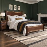 Diagonal angled room view showing the right side of a live edge panel bed with block posts, in a green-paneled bedroom.