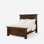Diagonal angled view showing the left side of a rustic panel bed, with a two-panel headboard and a matching footboard.